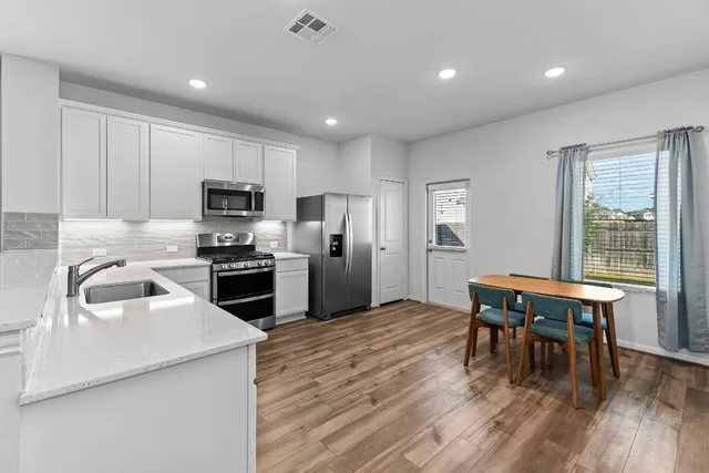 a kitchen with stainless steel appliances granite countertop a stove and a refrigerator