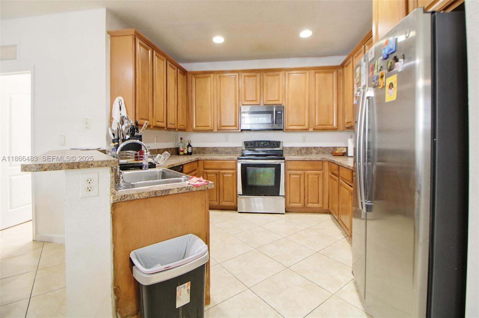 14077 Southwest 274th Terrace Homestead, FL 33032 - Photo 2 of 29 a kitchen with stainless steel appliances granite countertop a sink stove refrigerator and cabinets