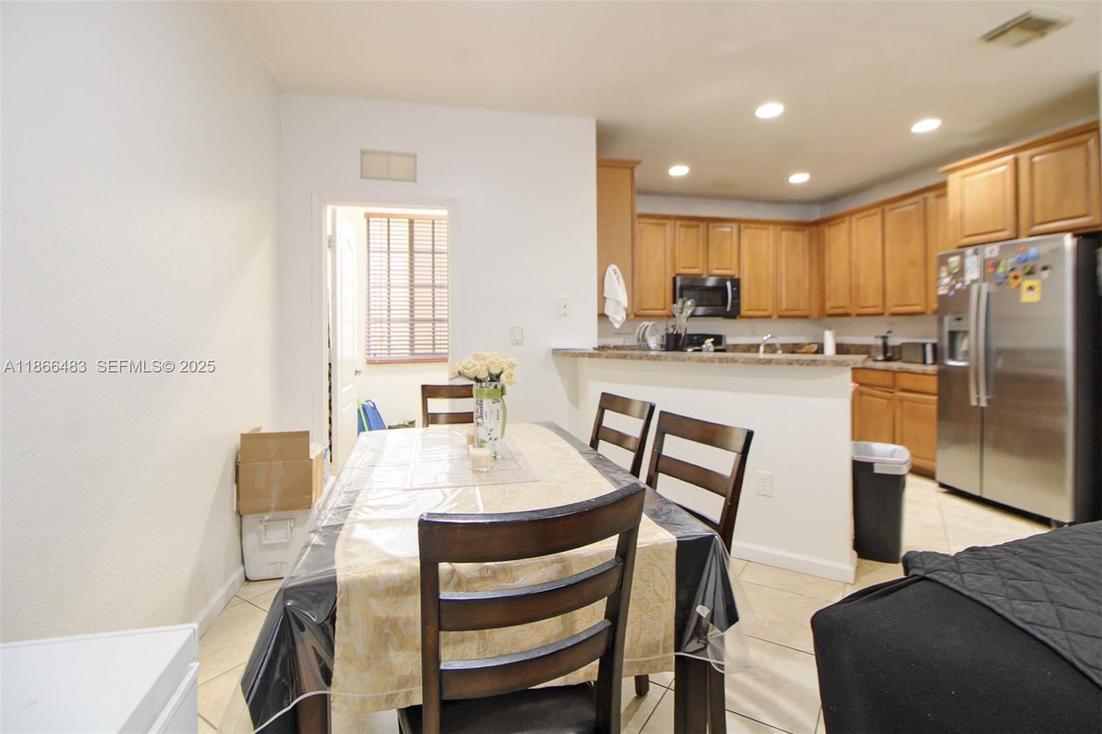 14077 Southwest 274th Terrace Homestead, FL 33032 - Photo 26 of 29 a kitchen with refrigerator a stove and chairs