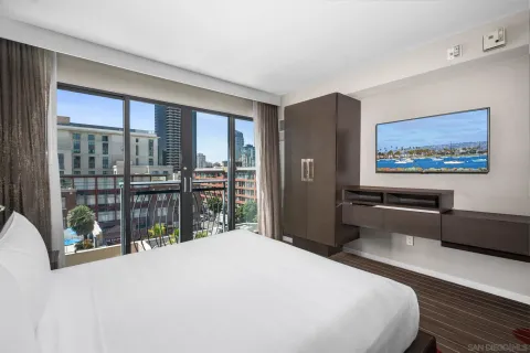 a bedroom with a large bed and a balcony view