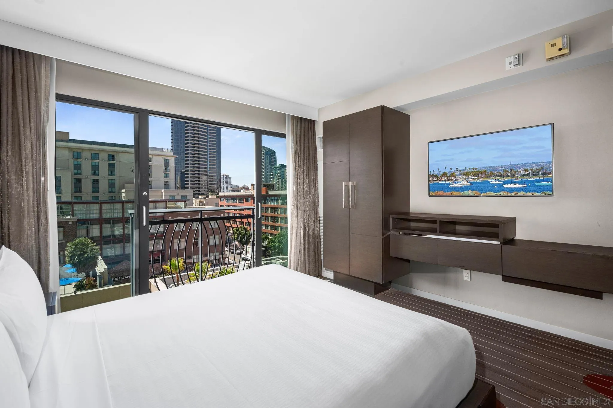 207 Fifth Avenue, Unit 739 San Diego, CA 92101 - Photo 3 of 30 a bedroom with a bed and a large window