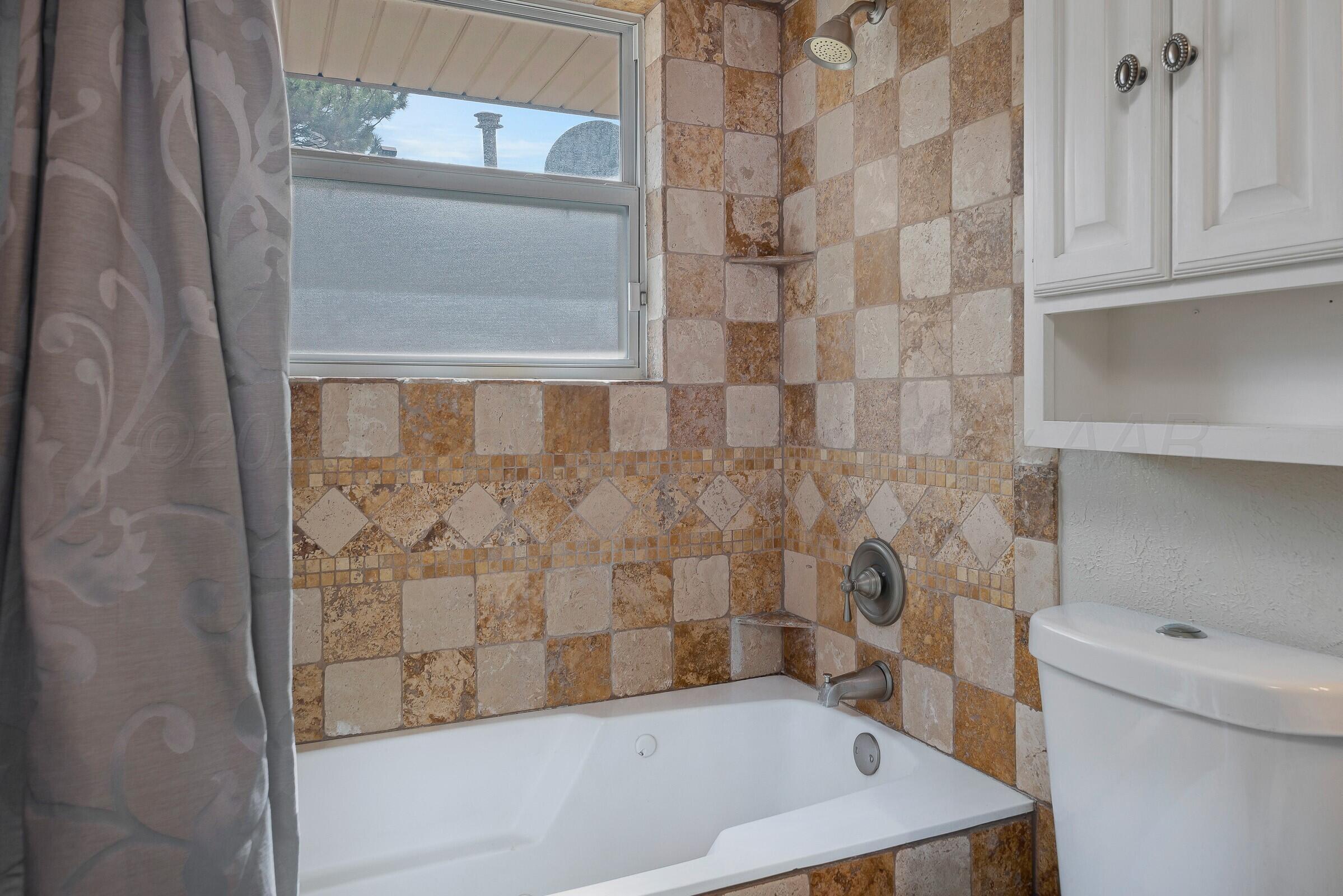 5211 Southwest 36th Avenue Amarillo, TX 79109 - Photo 14 of 22 a bathroom with a bathtub and a shower