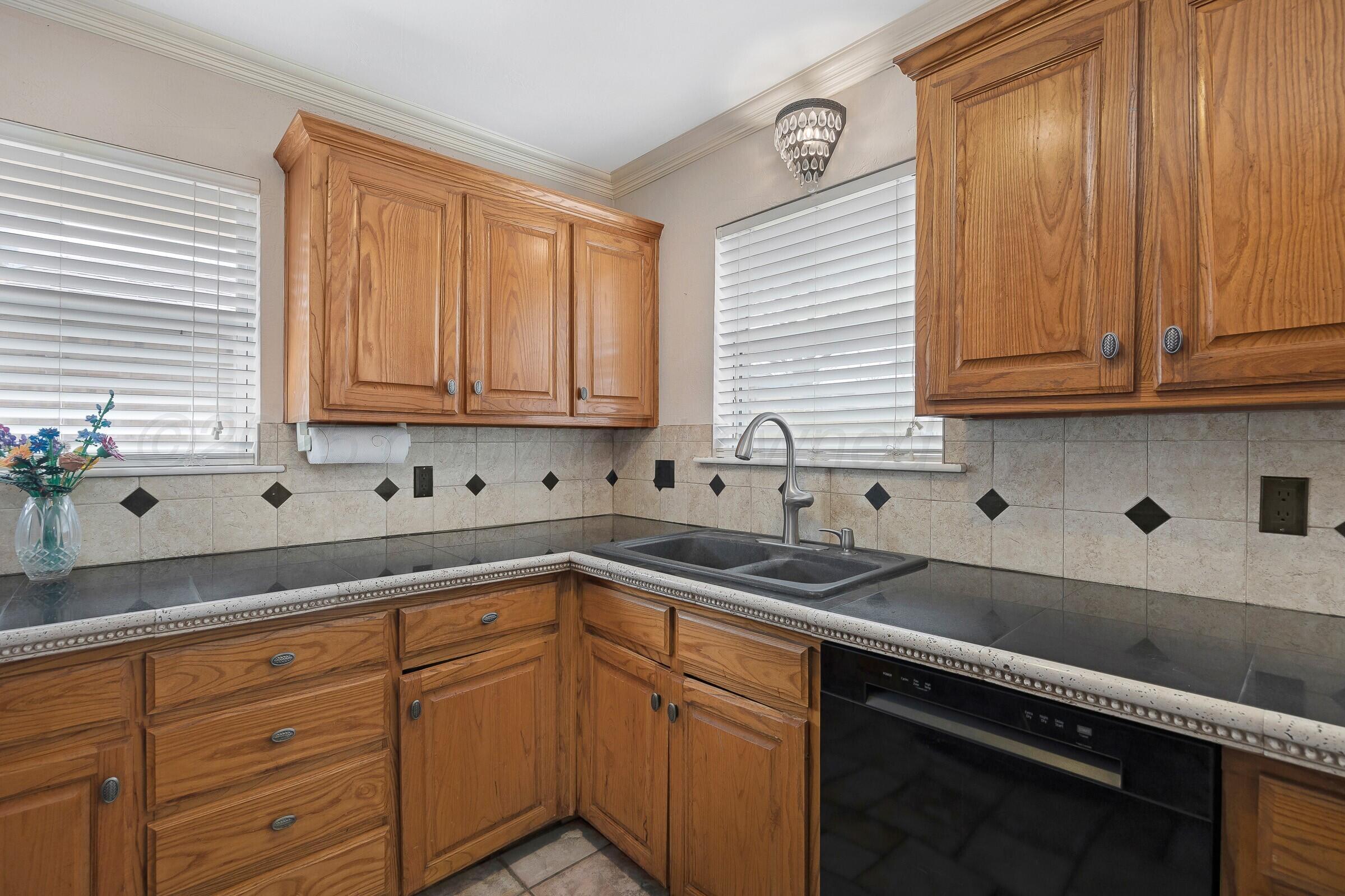5211 Southwest 36th Avenue Amarillo, TX 79109 - Photo 10 of 22 a kitchen with sink cabinets and potted plant