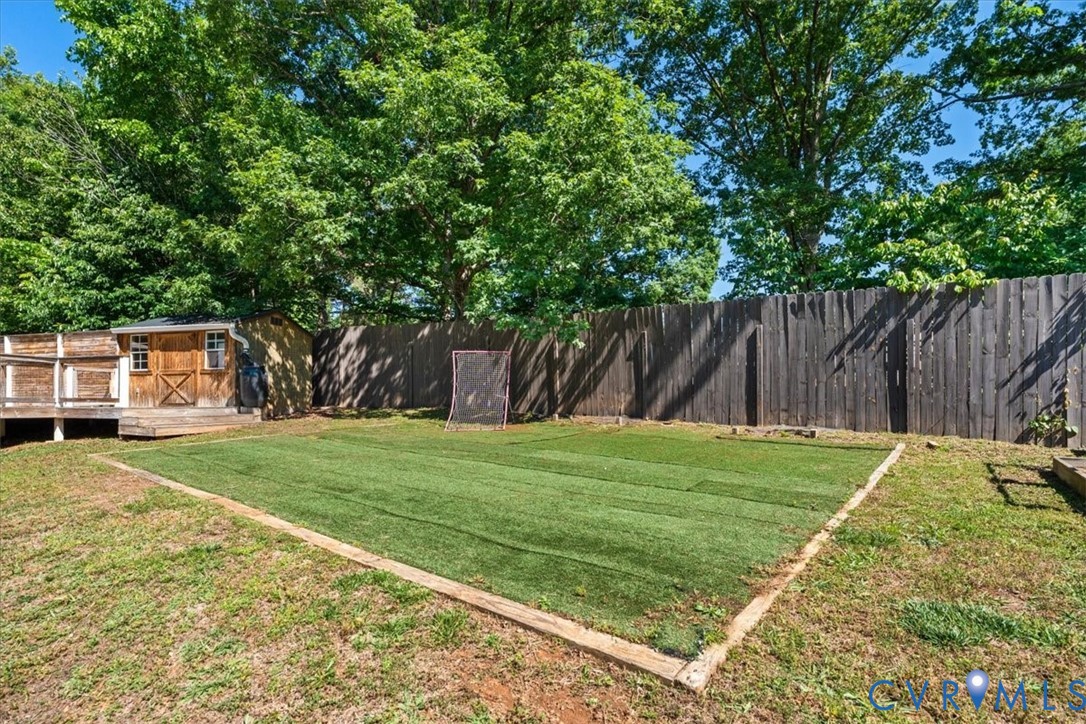 2043 Rocky Ford Road Powhatan, VA 23139 - Photo 53 of 78 a view of a backyard with table and chairs a barbeque and a large trees
