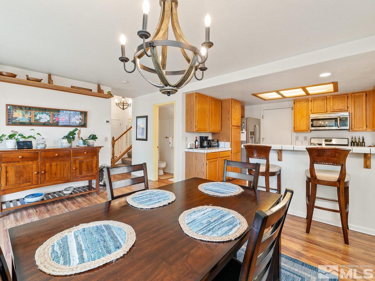 7593 Whimbleton Way Reno, NV 89511 - Photo 8 of 19 a dining room with furniture a wooden floor and chandelier