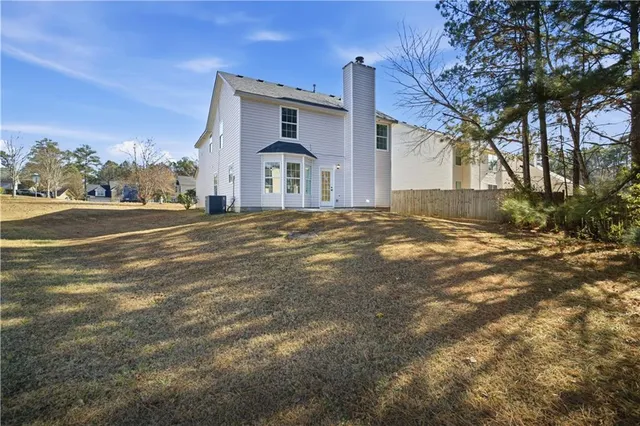 a view of an house with backyard and trees