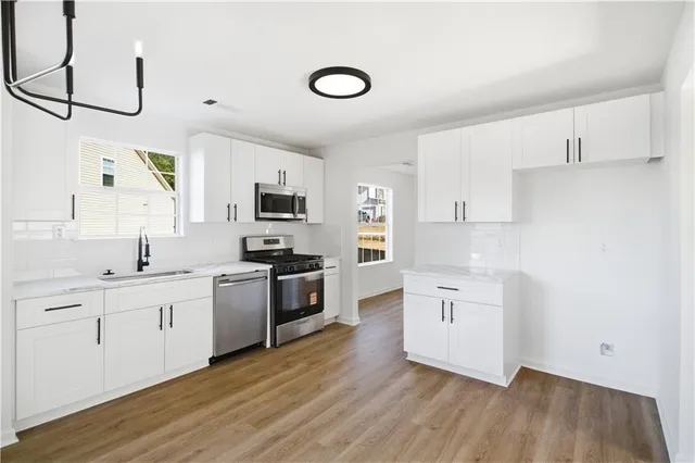 a kitchen with white cabinets stainless steel appliances and sink