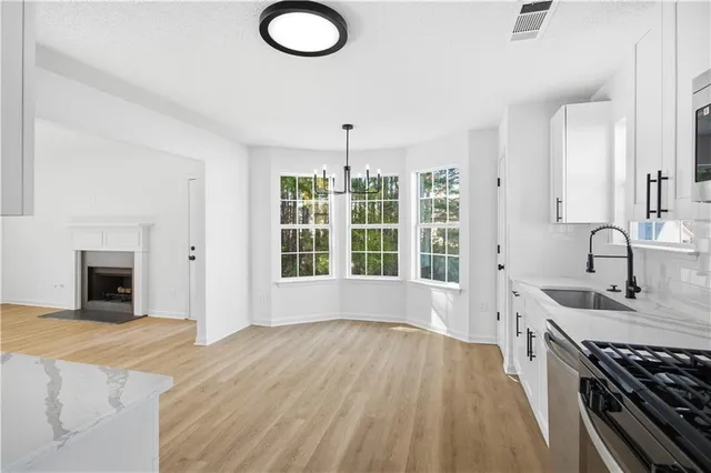 a kitchen with granite countertop a stove sink and dishwasher with wooden floor