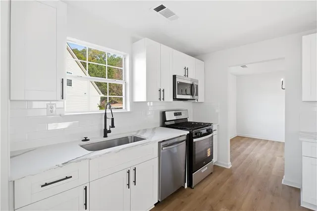 a kitchen with stainless steel appliances granite countertop a sink and a stove
