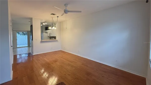 a view of empty room with wooden floor and a bathroom