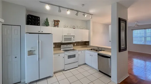 a kitchen with white cabinets and white appliances