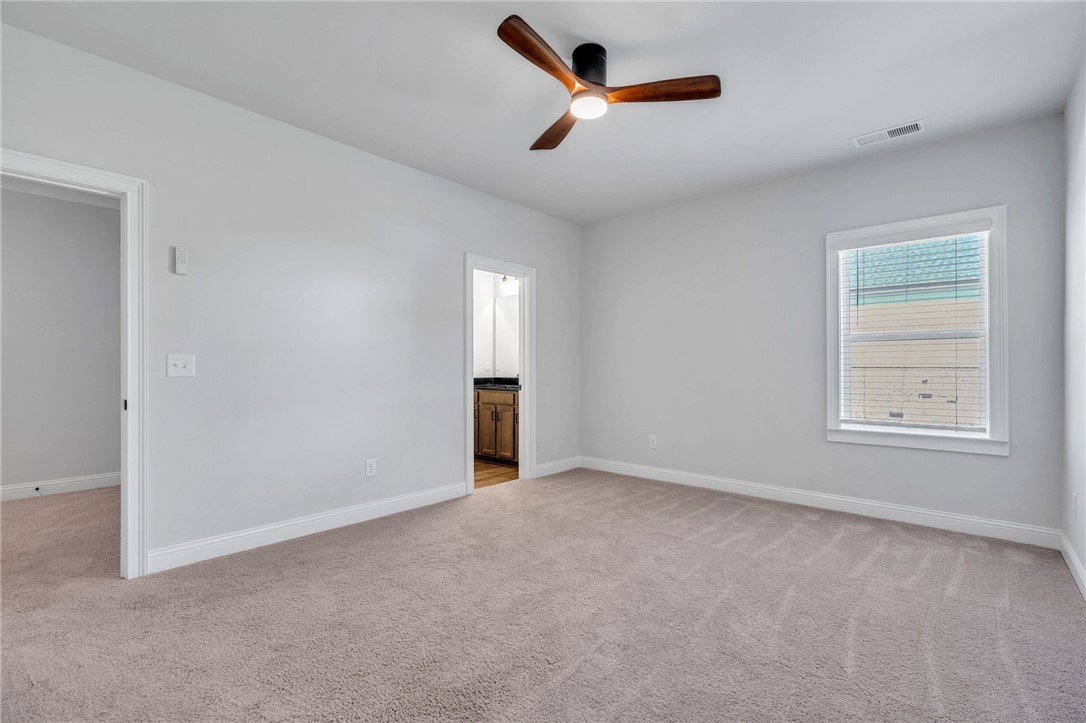 226 Holly Br Road Piedmont, SC 29673 - Photo 33 of 44 A spacious, naturally illuminated room featuring plush carpet flooring and a modern ceiling fan.