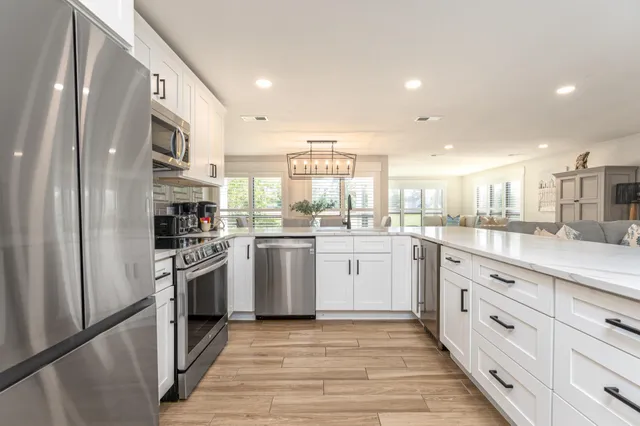 a kitchen with white cabinets stainless steel appliances and sink