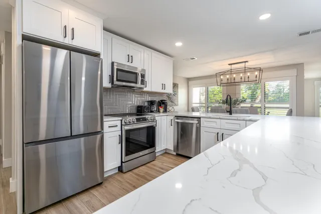 a kitchen with stainless steel appliances a refrigerator sink and microwave