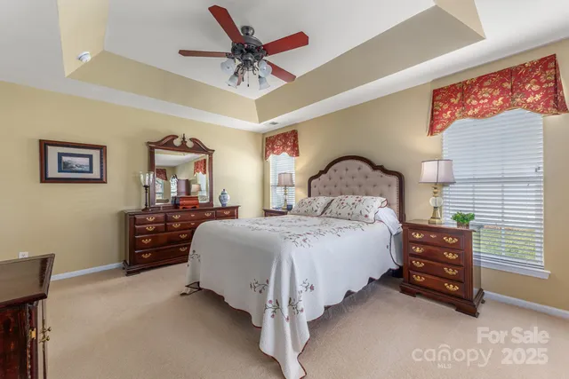 a spacious bedroom with a bed and a chandelier