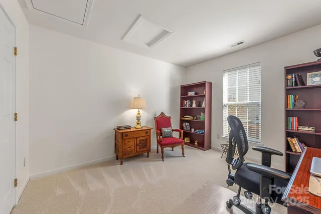 a view of a workspace with furniture and a bookshelf