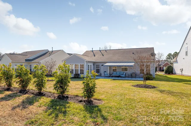 a view of a big house with a big yard and potted plants