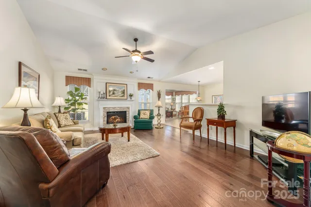 a living room with furniture a fireplace and a flat screen tv