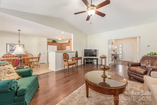 a living room with furniture a dining table and a chandelier