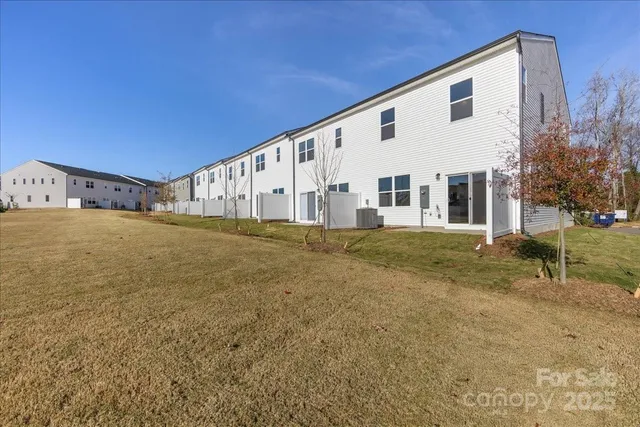 a view of a house with backyard and trees