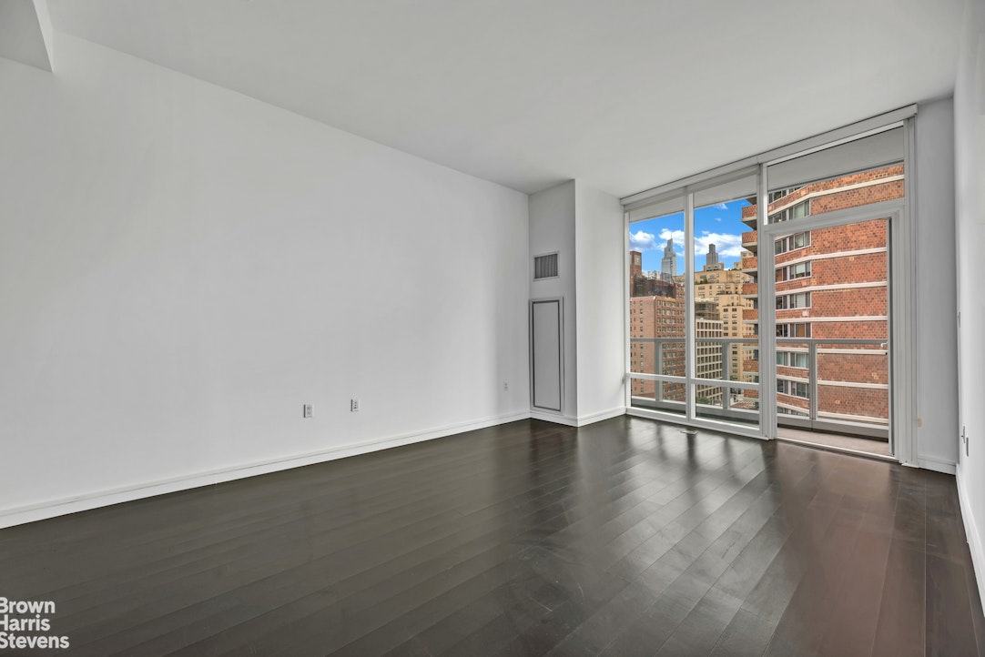 300 East 23rd Street, Unit 9B Manhattan, NY 10010 - Photo 1 of 14 a view of an empty room with wooden floor and a window