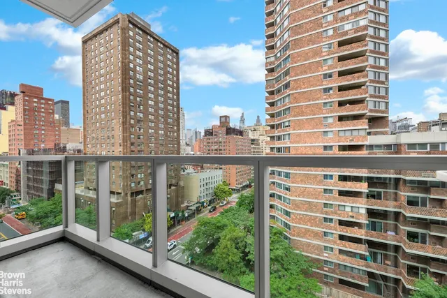 a view of balcony with a floor to ceiling window next to a tall building