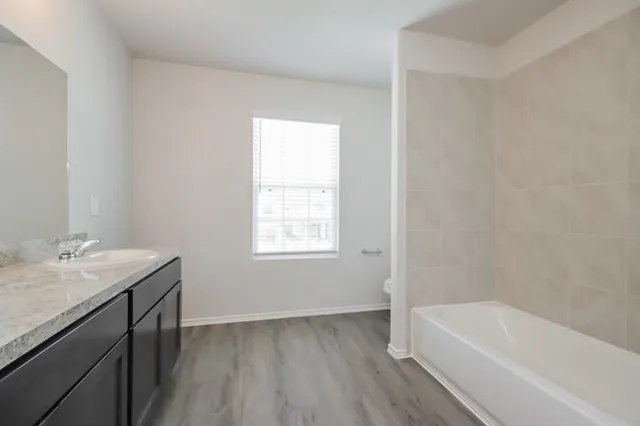 a bathroom with a sink a bathtub and a window