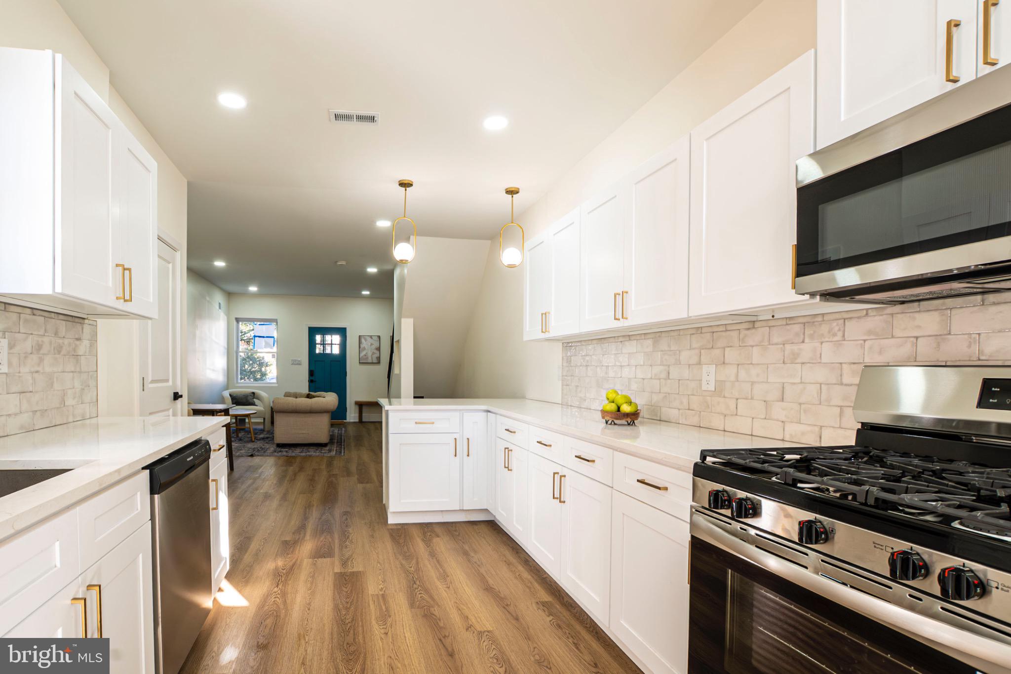 a kitchen with stainless steel appliances a stove a sink and a microwave