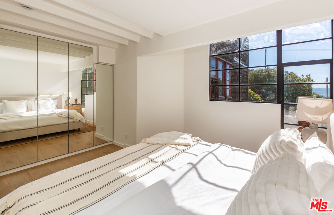 29233 Heathercliff Road, Unit 2 Malibu, CA 90265 - Photo 16 of 20 a bedroom with a bed and a large window