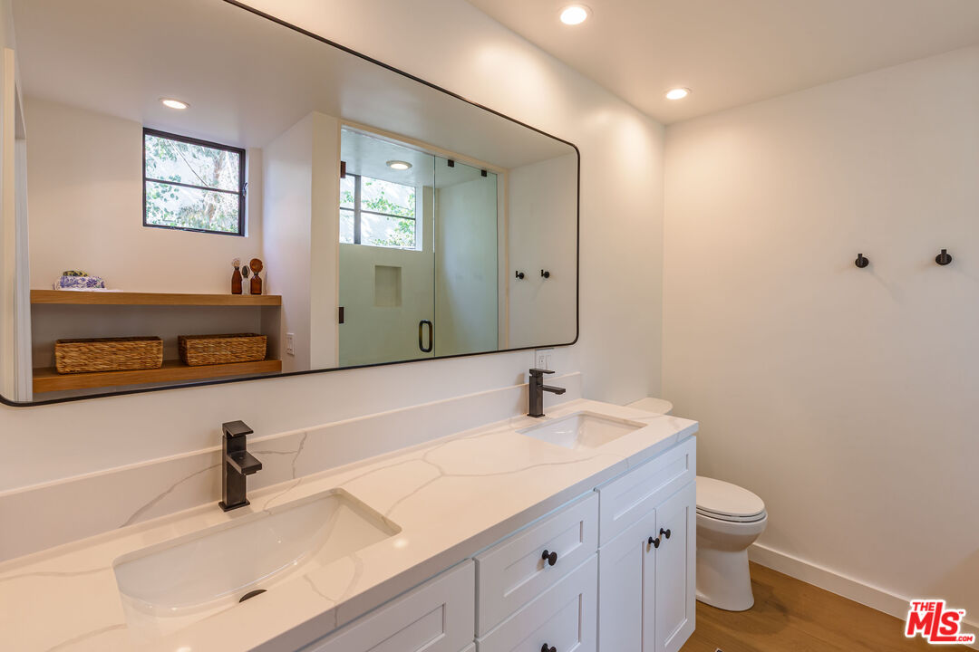 29233 Heathercliff Road, Unit 2 Malibu, CA 90265 - Photo 17 of 20 a bathroom with a double vanity sink and a mirror