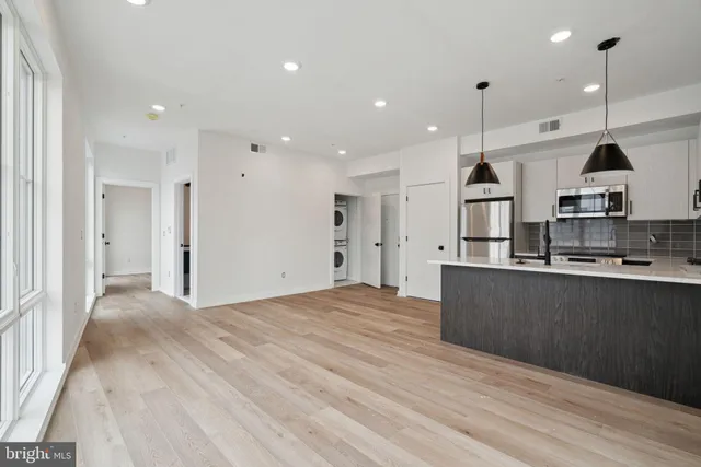 a view of kitchen with stainless steel appliances granite countertop cabinets and wooden floor
