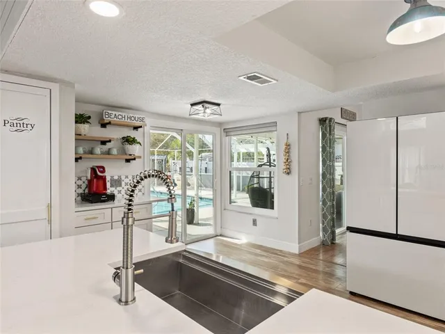 a view of a livingroom with wooden floor and a refrigerator