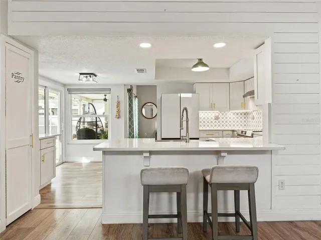 a kitchen with cabinets and chairs in it