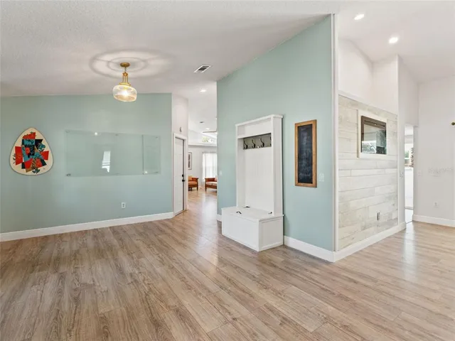 a view of a kitchen with wooden floor and an empty room