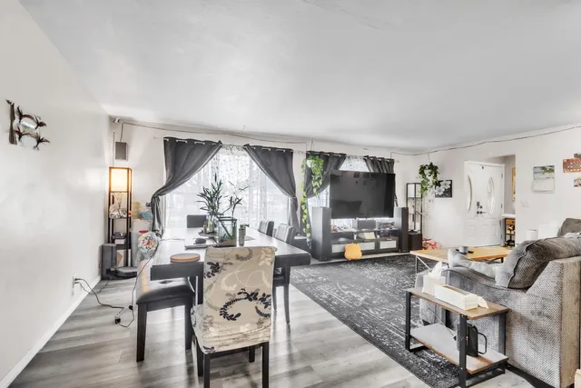 a living room with furniture and a flat screen tv with wooden floor