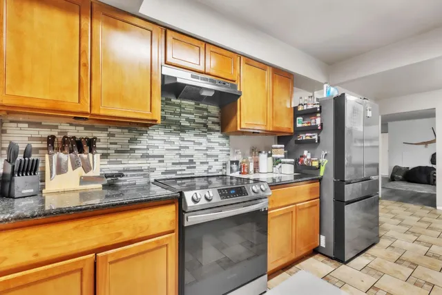 a kitchen with stainless steel appliances granite countertop a sink stove and refrigerator