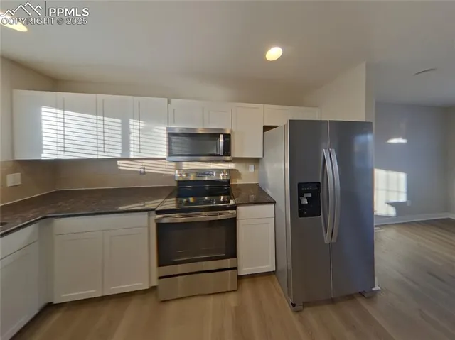 a kitchen with stainless steel appliances granite countertop a stove a refrigerator and a microwave