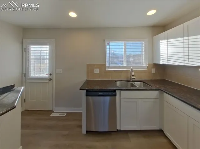 a kitchen with granite countertop a sink and a stove
