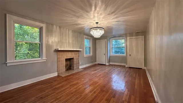 a view of a livingroom with wooden floor and a large window