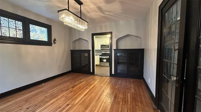 a view of a room with wooden floor staircase and a kitchen space