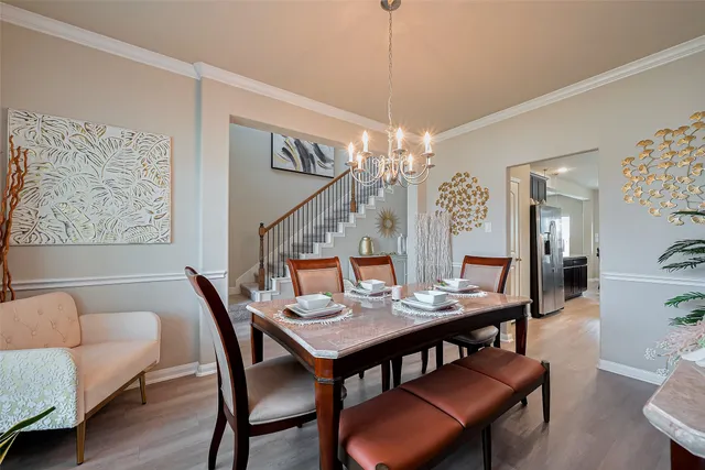 a view of a dining room with furniture a chandelier and wooden floor