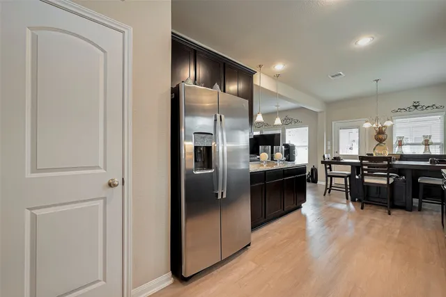 a kitchen with stainless steel appliances kitchen island granite countertop a refrigerator and a sink