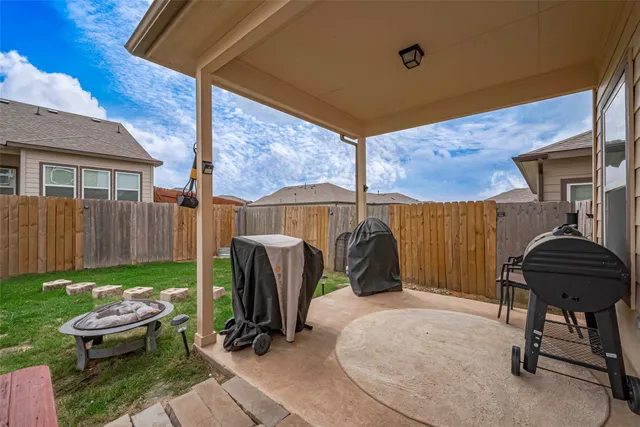 a view of a backyard with furniture and a grill