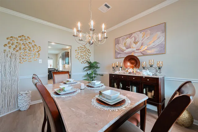 a view of a dining room with furniture a chandelier and wooden floor