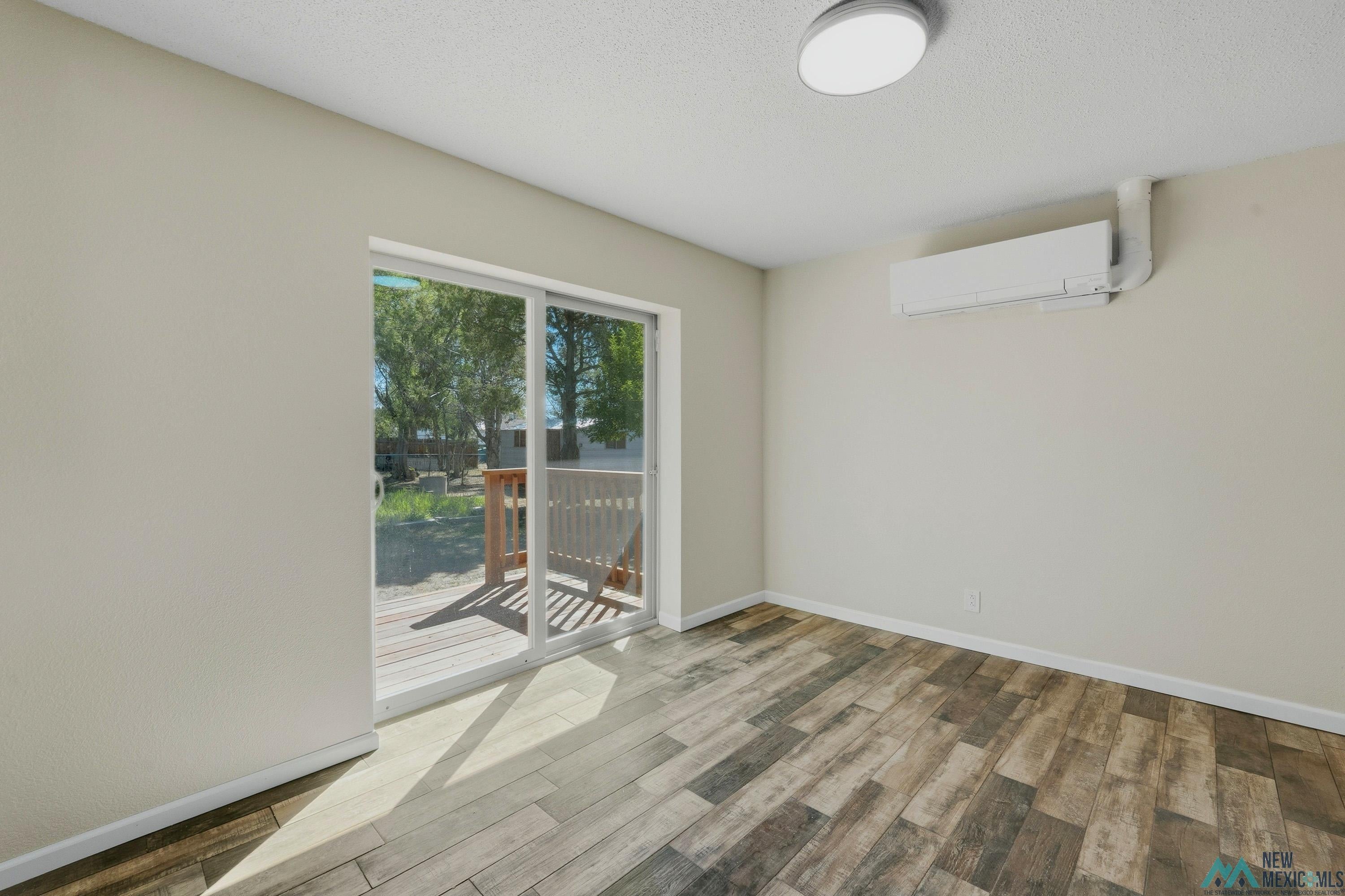 544 South 13th Avenue Raton, NM 87740 - Photo 9 of 37 Interior space featuring wood-finish flooring, light-toned walls, and a ceiling-mounted light fixture