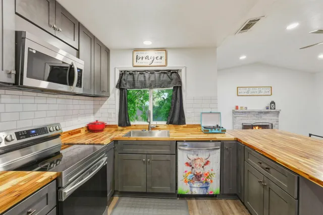 a kitchen with stainless steel appliances granite countertop a refrigerator and a stove top oven