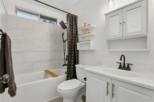 a bedroom with a bed and a flat tv screen on dresser