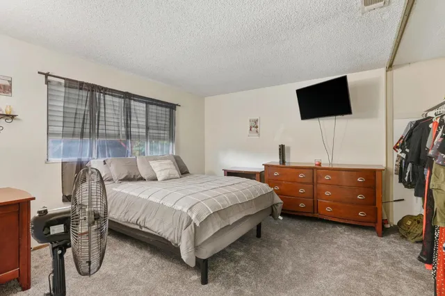 a bedroom with a bed a table and painting