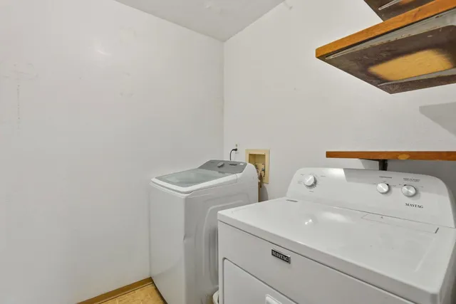 a view of a house with a yard and large tree