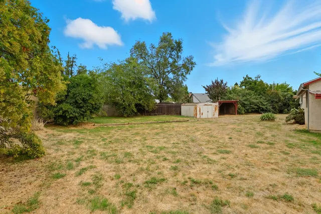 a backyard of a house with plants and trees